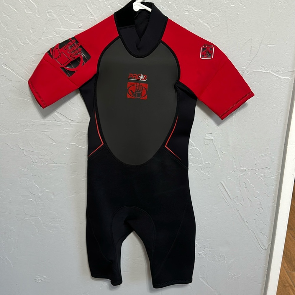 Body Glove youth size 10 wet suit. Black, gray with red sleeves. Short/halfie